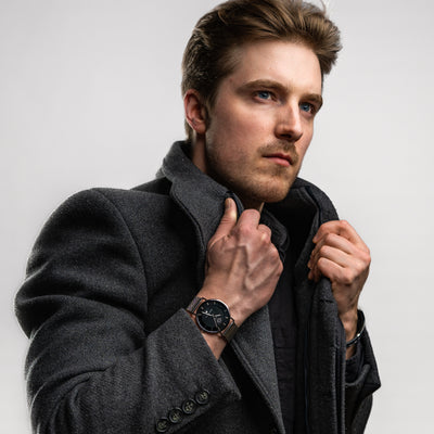 Man with coat and black and silver THT watch.