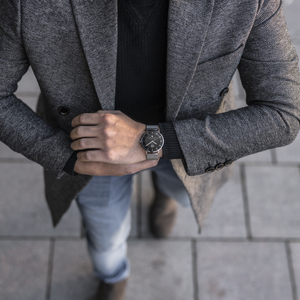 Man dressed up and checking time of his THT Arctica watch.